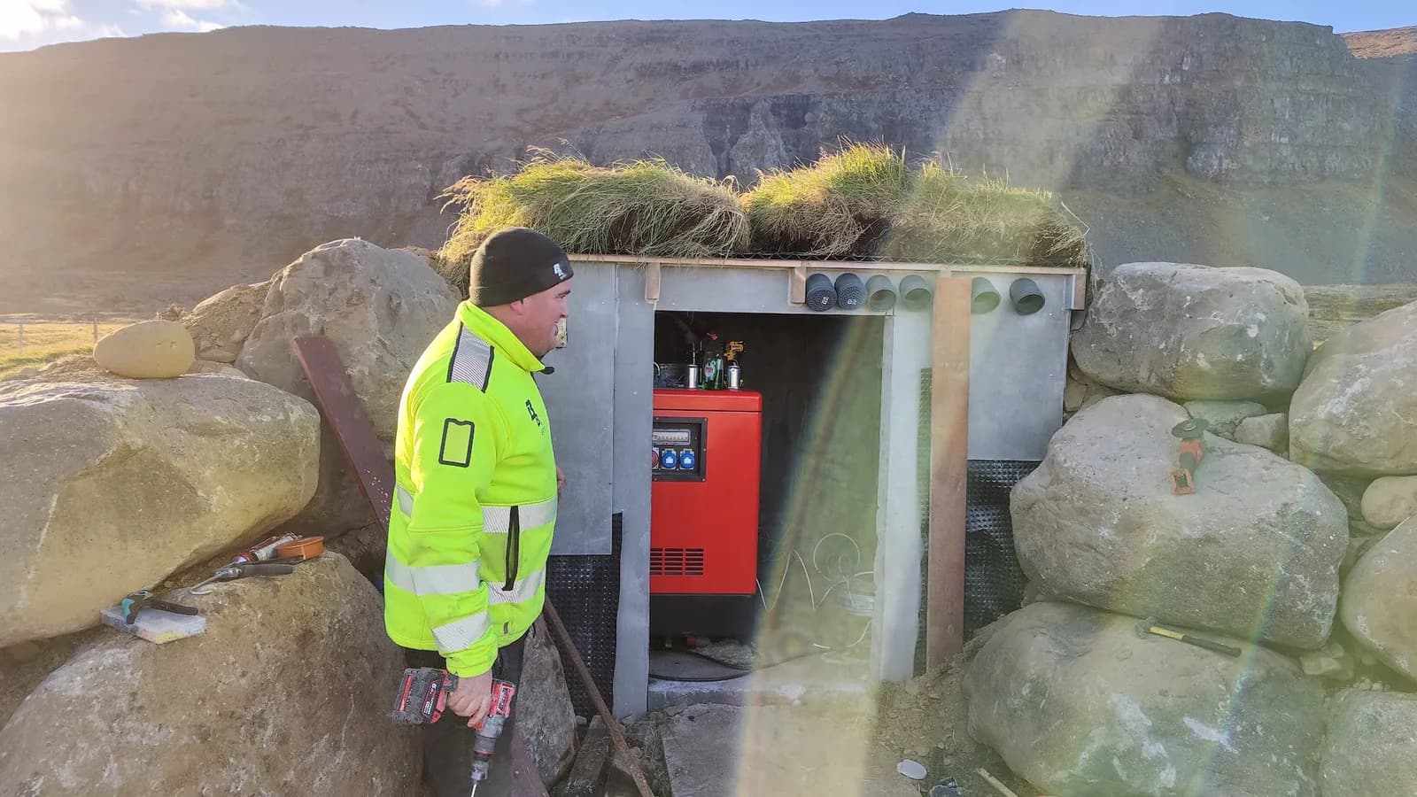 Starfsmaður við fjarskiptahús í fjalllendi